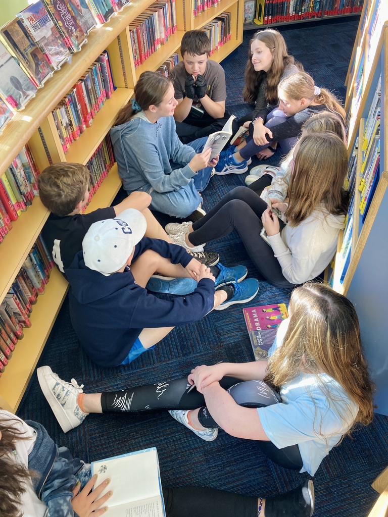 6th graders reading scary stories in our library