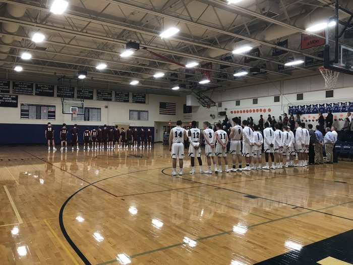 boys basketball players standing in line for the national anthem